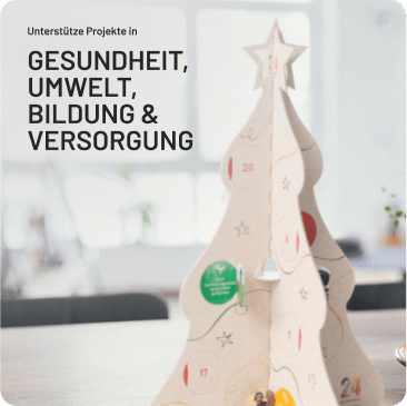 Adventskalender in Tannenbaumform auf einem Tisch, mit Text „Unterstütze Projekte in Gesundheit, Umwelt, Bildung & Versorgung